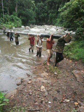 Difficult terrain - Carrying poles across river